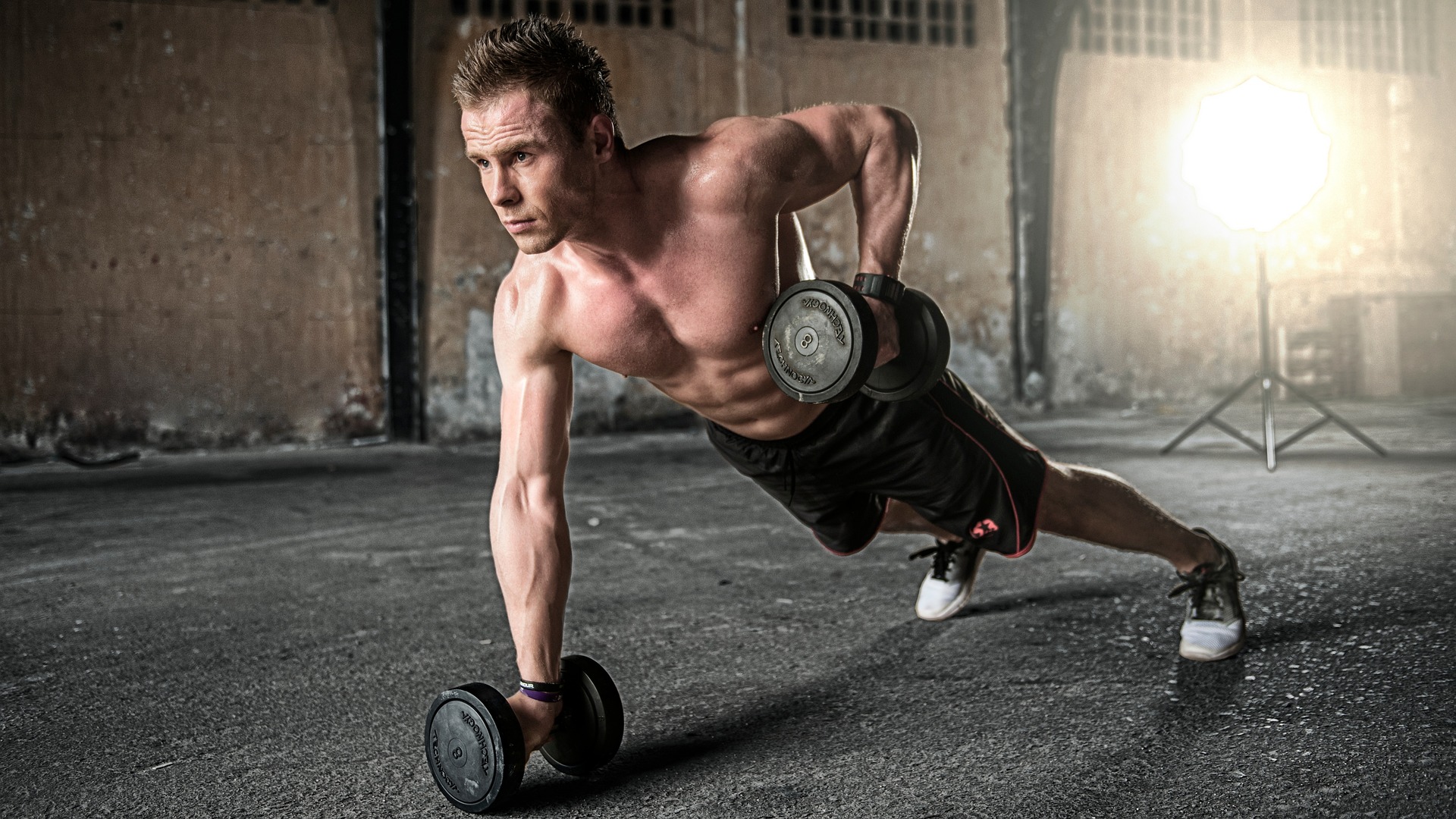 man doing renegade rows with dumbbells