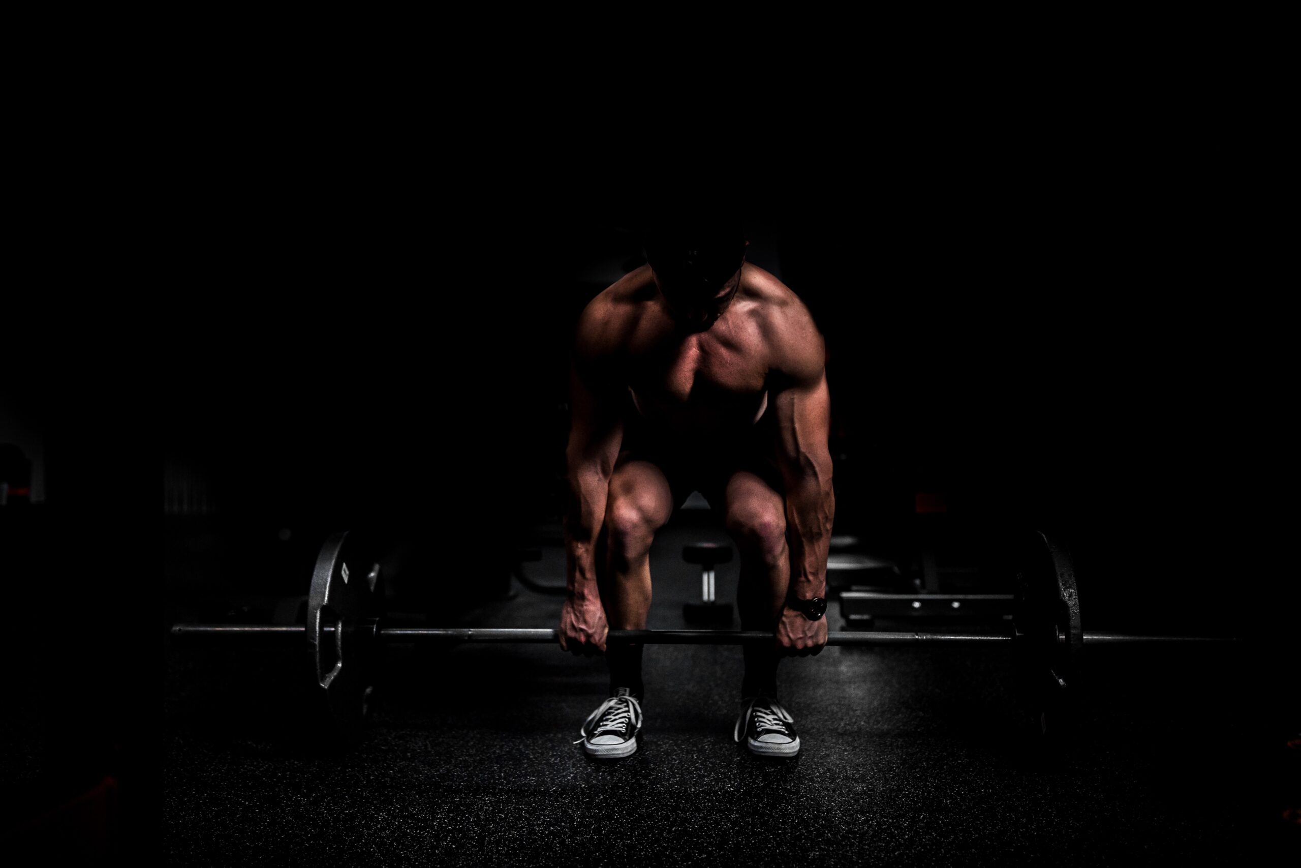 man lifting weights using the compound exercise, deadlift