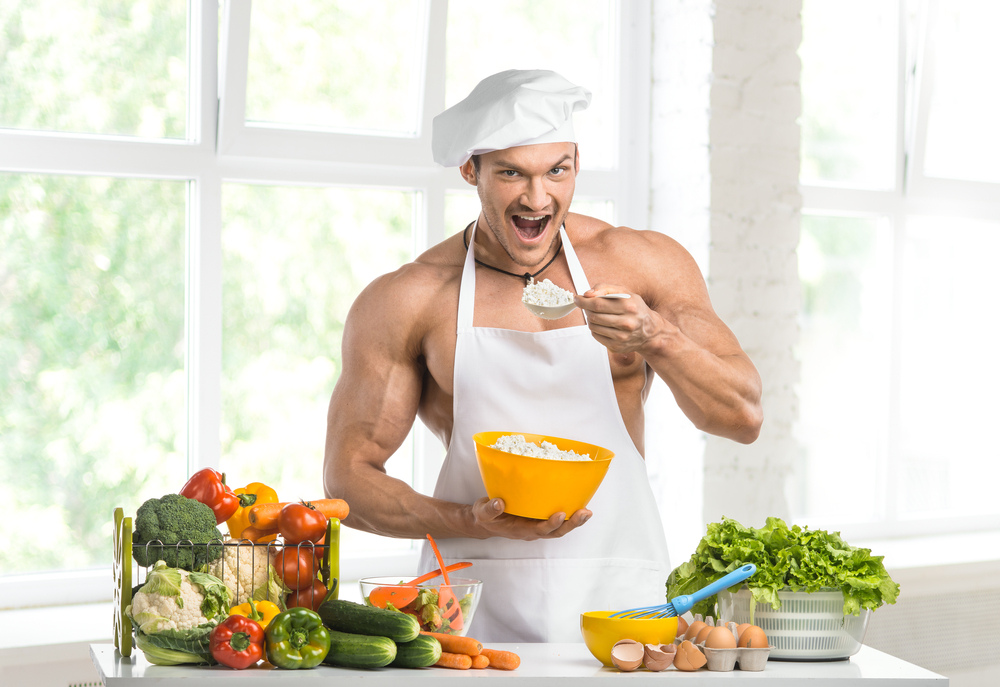 man in an apron and hat eating on a calorie deficit